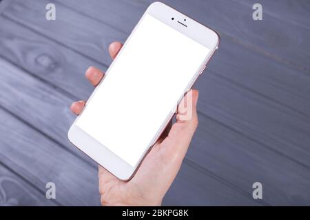 Mockup-Bild des handgehaltenen weißen Mobiltelefons mit leerem Desktop-Bildschirm Stockfoto
