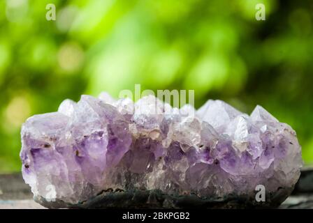 Amethyst. Naturkristall ohne Verarbeitung auf grünem Hintergrund. Platz für Text Stockfoto