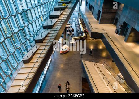 Reykjavik, Island. Innenarchitektur von Harpa, Konzertsaal und Konferenzzentrum mit einer markanten farbigen Glasfassade, die von Basalt inspiriert ist. Stockfoto