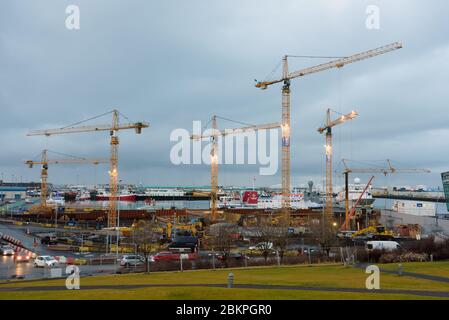Große Baustelle mit mehreren Kranen, die an einem Gebäudekomplex in Reykjavik, Island, arbeiten. Stockfoto