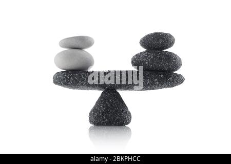 Ausbalancierende schwarze und weiße Steine auf weißem Hintergrund isoliert Stockfoto