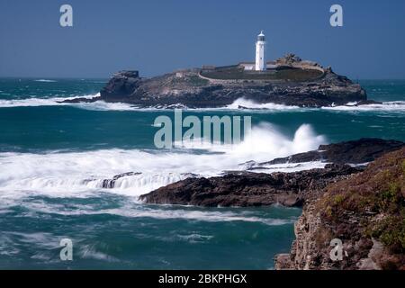 Ein Blick auf den Leuchtturm von Godrevy von den Felsen am Strand von Gwithian an der Nordküste Cornwalls. Stockfoto