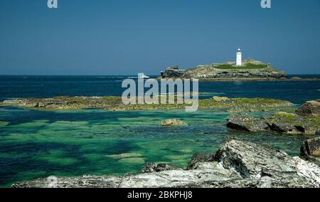 Ein Blick auf den Godrevy Lighthouse von den Felsen am Gwithian Beach an der North Cornwall Küste, Großbritannien Stockfoto