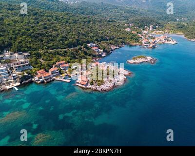 Luftaufnahme von Kakrc im Kotor Fjord in Montenegro. Häuser und Gebäude am Meer. Mediterrane Macchia Vegetation und unberührte Natur Stockfoto