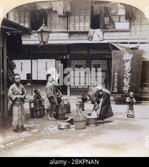 [ 1890er Japan - Japanische Frau Waschen Kleidung ] - EINE Frau wascht Kleidung mit Oke (hölzerne Wannen) auf einer Straße in Yokohama. Vintage-Stereoansicht aus dem 19. Jahrhundert. Stockfoto