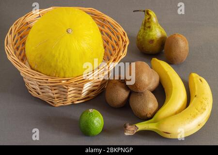 Melone in einem Korb und Obst an der Seite. Obst für ein leckeres und gesundes Frühstück. Stockfoto