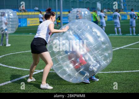 Bubble Football. Frau hilft Spieler, innerhalb der Blase ausgeglichen zu bekommen. 12. August 2019. Kiew, Ukraine Stockfoto