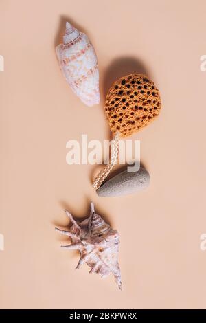 Natürliche Spa- und Hautpflegeprodukte mit Badezubehör, darunter Naturschwamm, Bimsstein mit Muscheln. Flaches Lay-Muster mit Kopierraum in der Mitte. Stockfoto