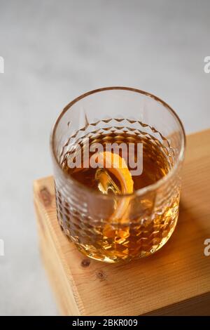 Alkoholisches Getränk im Glas mit Eiswürfeln auf einem Holztisch, Whiskey im Glas Stockfoto