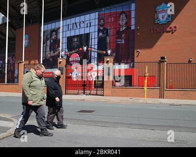 4. Mai 2020, Liverpool, Vereinigtes Königreich; Stadion Anfield während der Aussetzung der Premier League wegen der Coronavirus-Pandemie; ein Mann mit einer Gesichtsmaske geht am verlassenen Eingang zum Kop vorbei Stockfoto