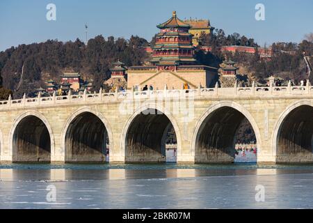 Siebzehn Bogen Brücke, Shiqikong Qiao im Sommerpalast, mit Turm des buddhistischen Räucherstäbchen auf dem Longevity Hill im Hintergrund, Peking, China Stockfoto