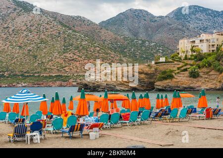 Bali, Kreta, Griechenland - 7. Oktober 2019: Spektakuläre Aussicht auf den Strand mit bunten Sonnenschirmen und Sonnenliegen vor der Kulisse des majestätischen Berges Stockfoto