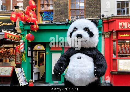 Eine riesige Panda Figur vor den Geschäften und Restaurants in Wardour Street in Chinatown, Soho, London, dekoriert für chinesisches Neujahr Stockfoto