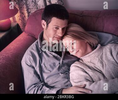 Paar 25-30 Jahre zusammen sitzen, ruhig reflektierende romantische nachdenklich auf Wohnzimmer Sofa zu Hause Stockfoto