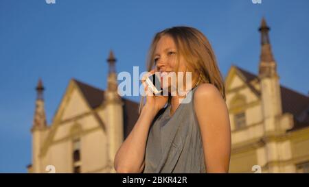Schöne Frau mit einem Anruf draußen in der Sonne. Stockfoto