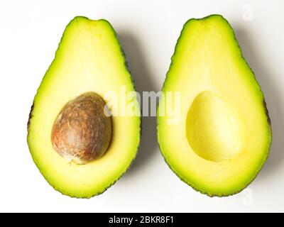 Zwei Avocado Hälften die gleiche Weise nach oben mit dem Stein links in einer Hälfte auf einem weißen Hintergrund Stockfoto