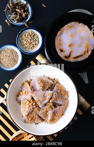 Gesundes Essen Konzept Veganer Glutenfreier hausgemachter asiatischer gebratener klebrischer Reis flacher Pfannkuchen mit Sesam und Sonnenblumenkernen auf schwarzem Boden mit Kopie Stockfoto