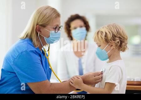 Kinderarzt Arzt Untersuchung kranken Kind in Gesichtsmaske. Kranker Junge in der Klinik für Test und Screening. Kinder zu Hause Behandlung von Virus. Coronavirus pand Stockfoto
