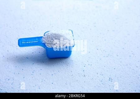 Blaue Messlöffel mit Waschpulver. Kopierbereich Stockfoto