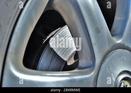 Zerstörter Scheibenbremsrotor, der durch die Felge eines Fahrzeugs gesehen wird Stockfoto