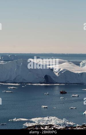 Teleaufnahme des Bootes zwischen den Eisbergen in der Disko Bucht Ilulissat Stockfoto