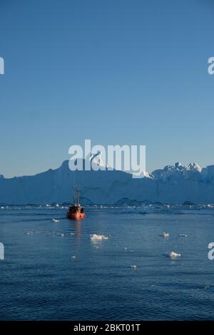 Teleaufnahme des Bootes zwischen den Eisbergen in der Disko Bucht Ilulissat Stockfoto