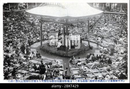 [ 1910 Japan - große Kanto-Flut, Tokyo ] - Menschen, die durch die Überschwemmungen vom August 1910 (Meiji 43), die heute als große Kanto-Flut bekannt sind (関東大水害, Kanto Dai Suigai), vertrieben wurden, suchen Zuflucht in der Kokugikan Sumo Hall in Tokio. Die Halle war im Vorjahr gerade eröffnet worden. Das Hochwasser, verursacht durch einen Sturm, versunkenen mehr als 201 Quadratkilometer und über 170,000 Wohnungen und Gebäude. Es gab 1,349 Tote oder Vermisste. Es war Tokyos drittschlimmste Flutkatastrophe des 20. Jahrhunderts. Vintage-Postkarte des 20. Jahrhunderts. Stockfoto