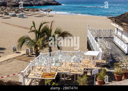 Palmen und geschlossene Strandbar am Strand Playa del Duque während der Schließung des Covid 19 im touristischen Ferienort Costa Adeje, Teneriffa, Kanarische Isla Stockfoto