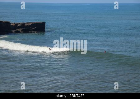 Männer in Neoprenanzügen mit Surfbrett an einem sonnigen Tag im Wasser - Strandsurfer sprechen und lachen, warten auf Wellen bei Sonnenaufgang - Extremsport und f Stockfoto