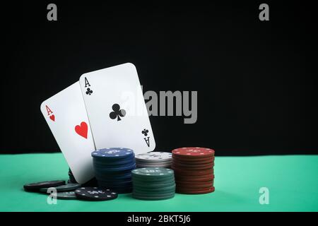 Ein Paar Asse auf einem Kartenspiel. Poker spielt Chips auf einem grünen Tisch. Online-Glücksspiel. Sucht. Spielkarten und Pokerchips. Kopierbereich Stockfoto