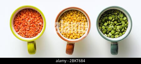 Banner von Linsen verschiedener Arten und Farben in portionierten Tassen. Vegane Proteine. Stockfoto