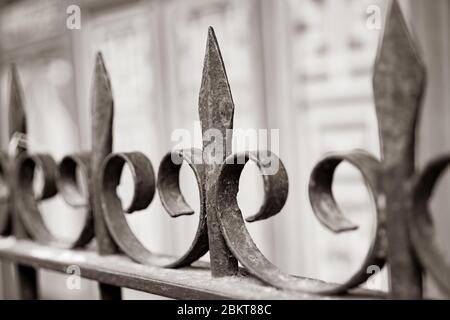 Schmiedeeiserne Spannspitzen und dekorative Lockenformen schließen sich im selektiven Fokus. In monochromen. Stockfoto