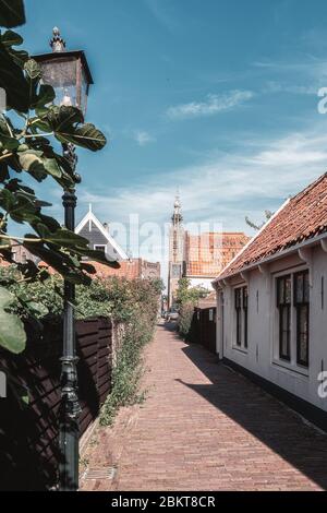 Eindruck des Kwakelsteeg in Edam mit dem Turm des Glockenspiels De Speeltoren im Hintergrund in den Niederlanden Stockfoto