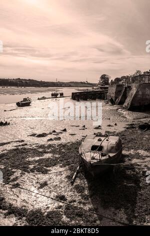 Ein Blick auf ein ausgestrahltes Segelschiff in Appledore, Devon, wenn die Flut auf dem Schlamm marooniert ist, der in Sepia-Tönen dargestellt ist Stockfoto