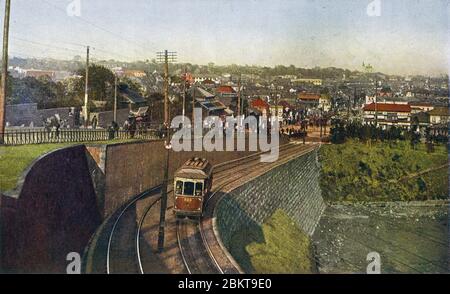 [ 1910 Japan - EINE Straßenbahn in Tokio ] - EINE Straßenbahn in Kudanzaka, Tokio. Am Horizont ist die Tokyo Resurrection Cathedral in Kanda zu sehen. Die orthodoxe Kirche wurde von St. Nikolaus von Japan gegründet und mit dem Spitznamen Nikorai-do. Vintage-Postkarte des 20. Jahrhunderts. Stockfoto