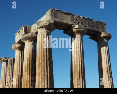 Dorische Säulen des Archaischen Tempels zu Apollo in Korinth, Peloponnes, Griechenland gegen einen blauen Himmel Stockfoto