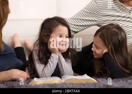 Großeltern, die Enkelkinder über die Heilige Bibel unterrichten Stockfoto