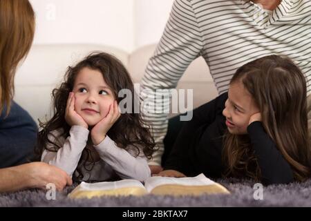 Großeltern, die Enkelkinder über die Heilige Bibel unterrichten Stockfoto