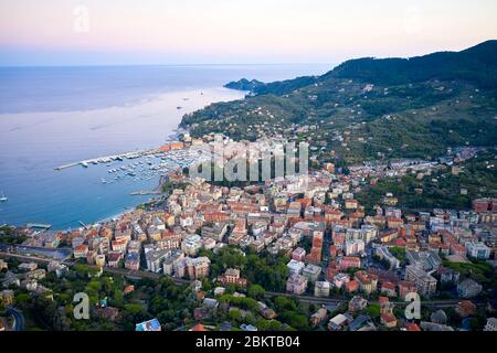 Panoramablick auf den Yachthafen in Santa Margherita Ligure bei purpurem Sonnenuntergang. Italienische Landschaft mit bunten traditionellen Häusern und Ligurisches Meer, in der Nähe Stockfoto