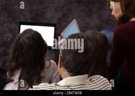 Familie unterrichtet Kinder zu Hause auf elektronischen Geräten Stockfoto