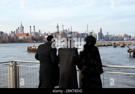 New York, Amerika, US : 20/12/2019: jüdische Familie genießt Blick auf Manhattan Skyline von Wolkenkratzern Gebäude Empire State Building & Chrysler Building Stockfoto