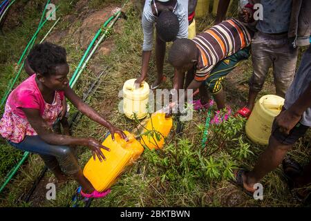 Nairobi, Kenia. April 2020. Kinder werden gesehen, wie sie Wasser aus einer laufenden Wasserleitung in Kibera ohne ihre Gesichtsmarks holen und nicht während der Coronavirus-Krise soziale Distanzierungen mindern. Kredit: Donwilson Odhiambo/ZUMA Wire/Alamy Live News Stockfoto