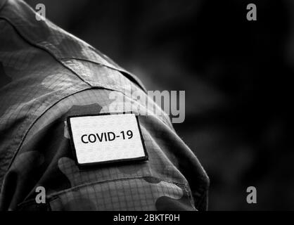 COVID-19 Inschrift auf Militäruniform. COVID-19-Konzept. Coronavirus Kriegskonzept. Leerraum für Text Stockfoto