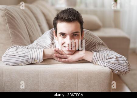 Teenager junger Mann auf dem Sofa zu Hause liegen Stockfoto