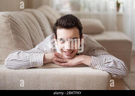 Teenager junger Mann auf dem Sofa zu Hause liegen Stockfoto