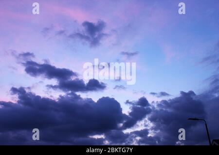 Violetter Sonnenuntergang mit dunklen Wolken in Manchester, England Stockfoto