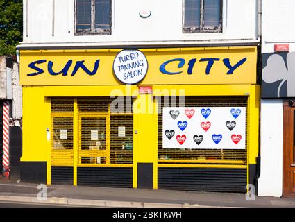 Sun City Tanning Salon, High Street, Beckenham, London, Großbritannien. Gesperrt während der COVID-19-Epidemie, mit Zeichen unterstützt NHS. Stockfoto