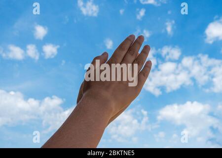 Beifall. Kid Hände applaudieren über blauen Himmel Hintergrund. Ansicht mit niedrigem Winkel Stockfoto