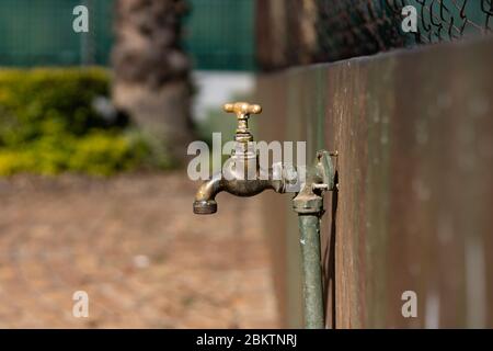 Alte geschlossene Wasserhahn an einer Außenwand in Pretoria befestigt Stockfoto