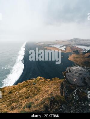 Moody Black Sand Beach in Island während des regnerischen und nebligen Wetters spiegelt sich die typischen Wetterbedingungen der nördlichen Länder Stockfoto